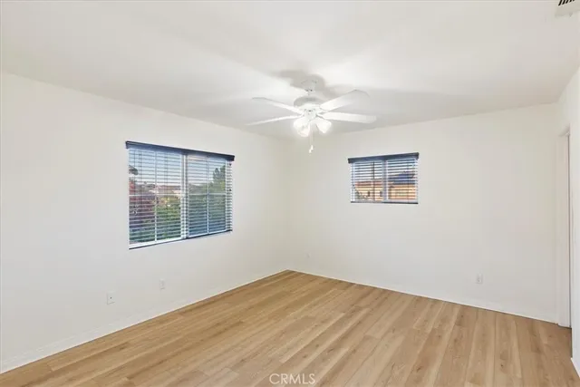 a view of a room with wooden floor and ceiling fan