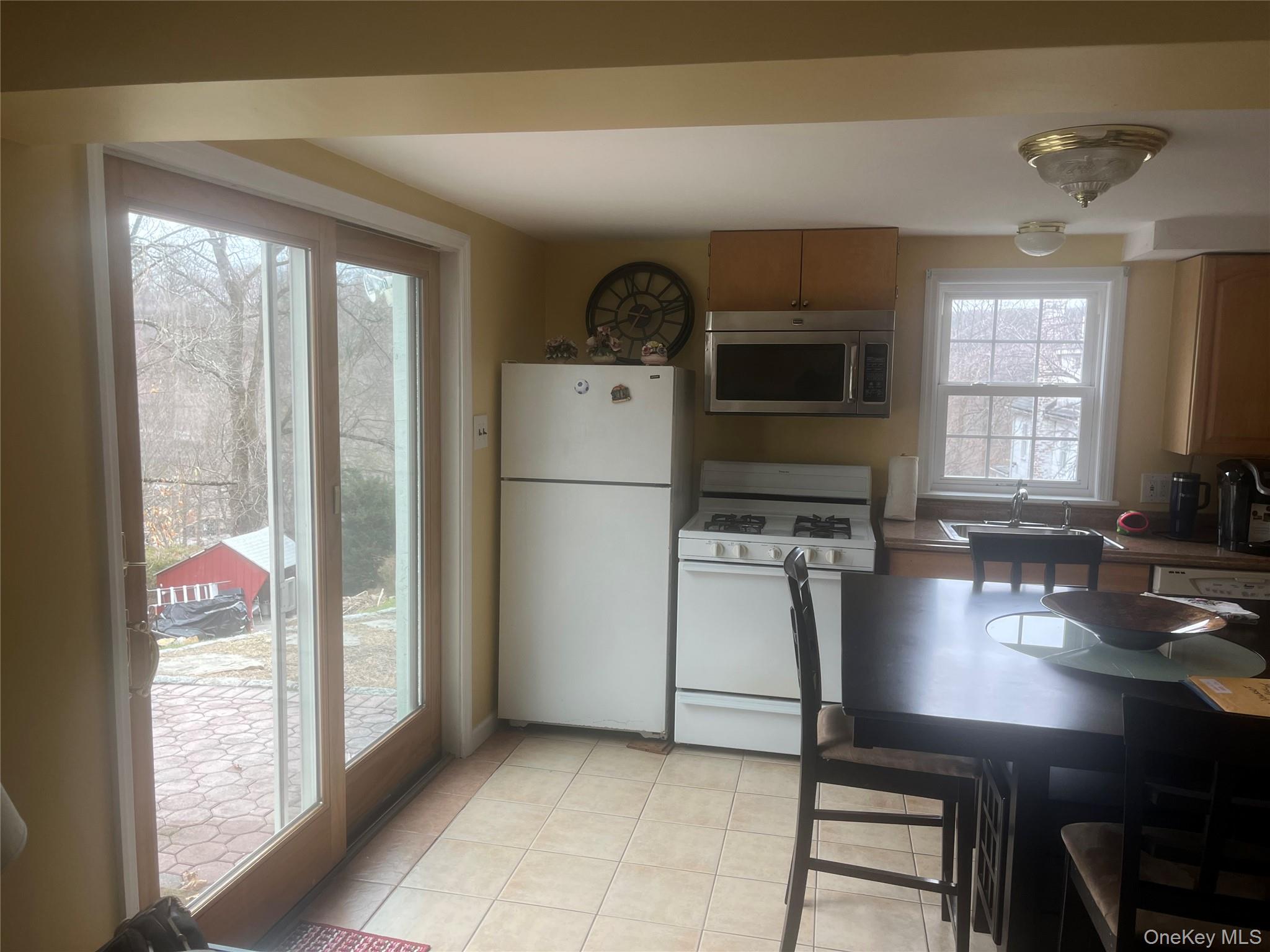 13 Summitt Place Valhalla, NY 10595 - Photo 3 of 10 a kitchen with a refrigerator a stove and a microwave oven