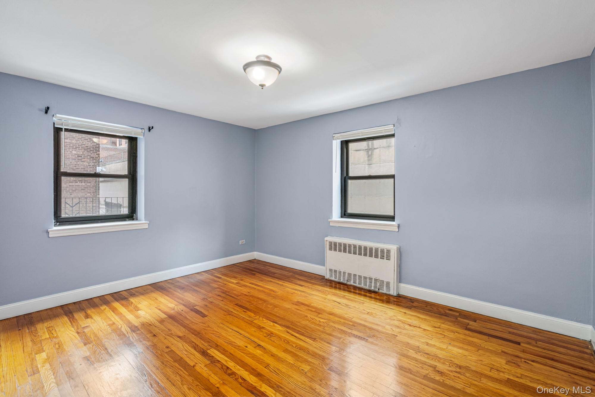 102-55 67th Road, Unit 2V Queens, NY 11375 - Photo 10 of 14 a view of an empty room with wooden floor and a window