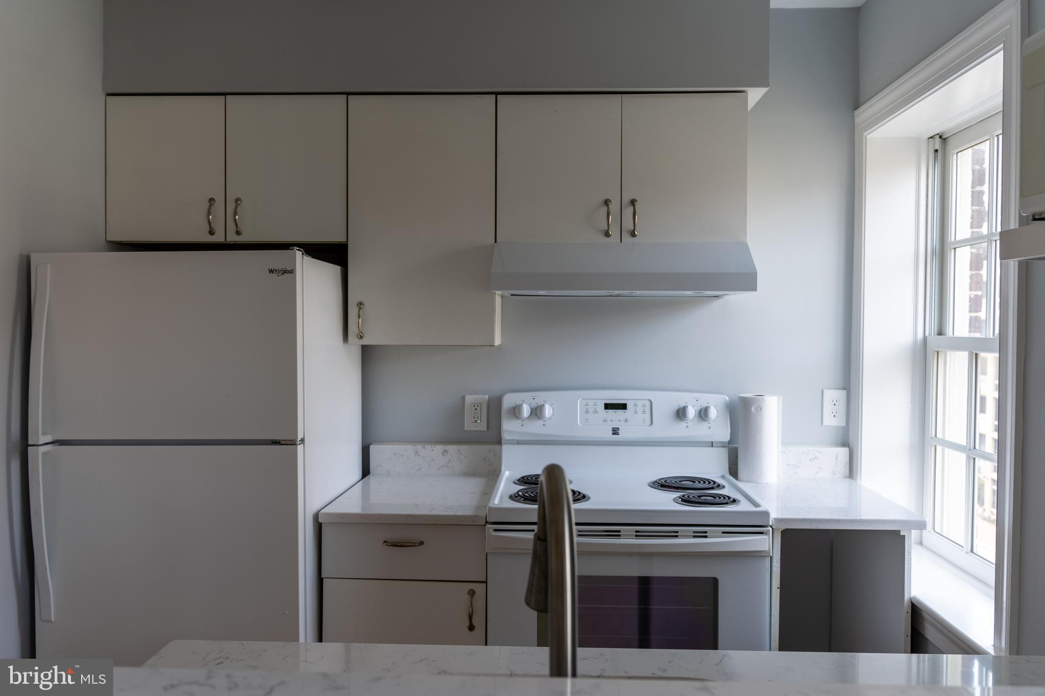 1426 21st Street Northwest, Unit 407 Washington, DC 20036 - Photo 19 of 58 a kitchen with granite countertop white cabinets and white appliances
