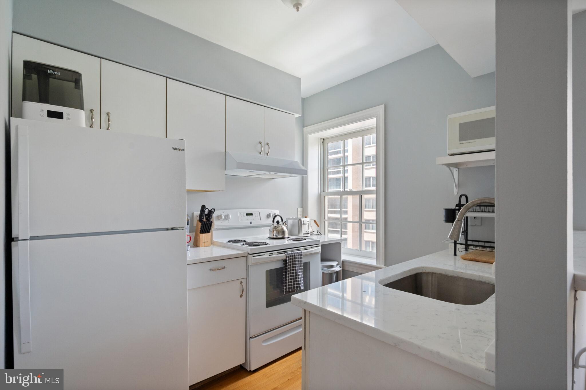 1426 21st Street Northwest, Unit 407 Washington, DC 20036 - Photo 9 of 58 a kitchen with a sink a stove and refrigerator
