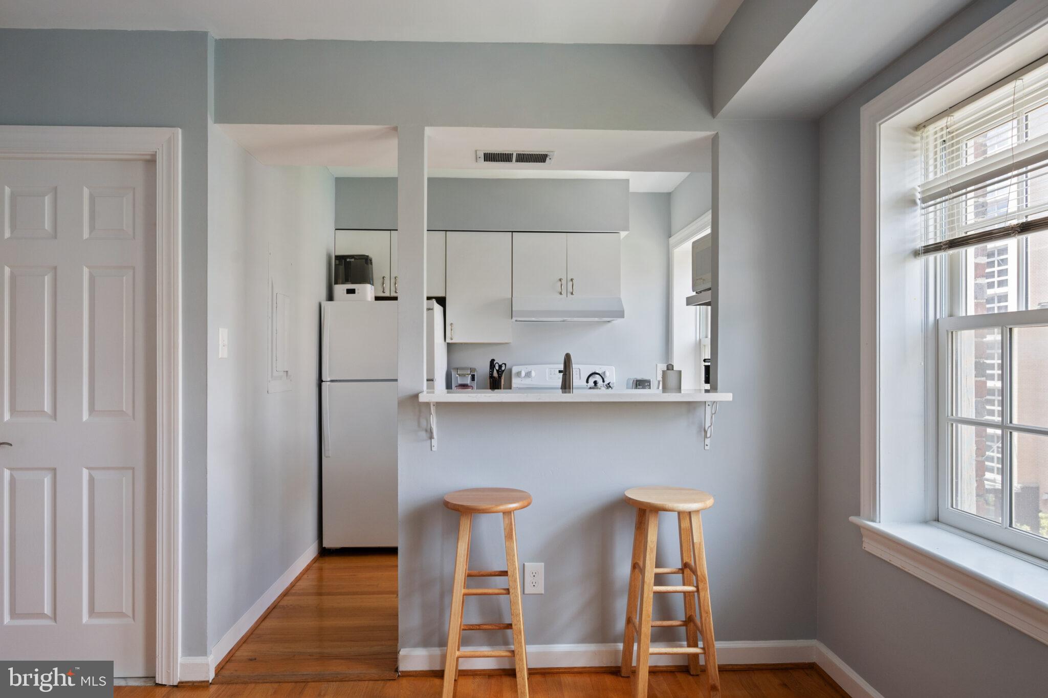 1426 21st Street Northwest, Unit 407 Washington, DC 20036 - Photo 10 of 58 a kitchen with stainless steel appliances granite countertop white cabinets a sink and a window