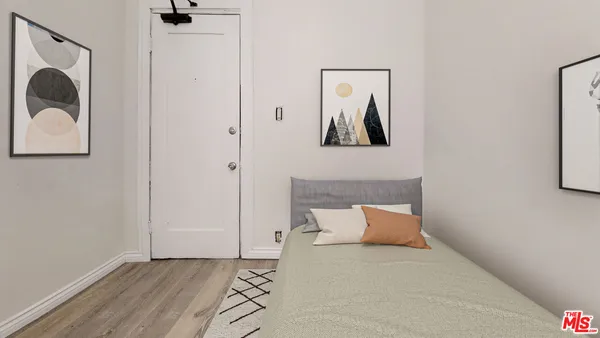 a bedroom with a bed and a painting on the wall