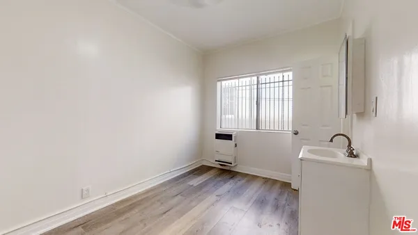a room with a sink and wooden floor
