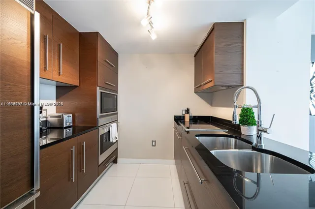 a kitchen with granite countertop a sink and a stove top oven