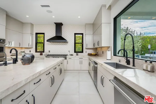 a large kitchen with stainless steel appliances granite countertop a sink and cabinets