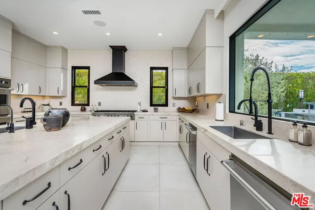 a large kitchen with stainless steel appliances granite countertop a sink and cabinets