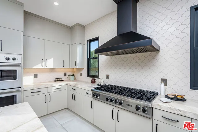 a kitchen with white cabinets and appliances