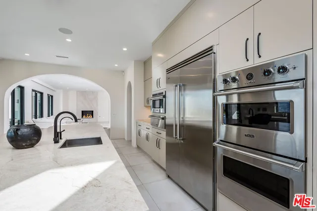 a kitchen with stainless steel appliances kitchen island a sink stove and refrigerator