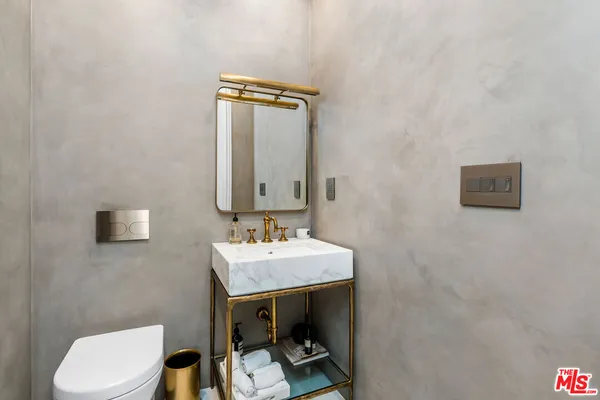 a bathroom with a toilet a sink and mirror