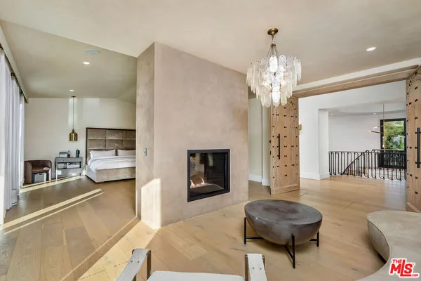a living room with furniture a fireplace and a chandelier