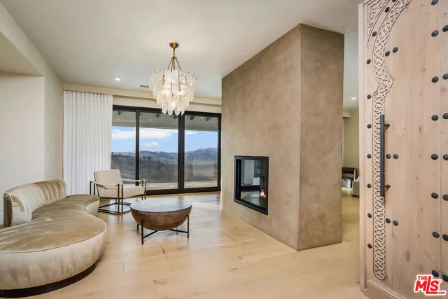 a living room with furniture and a chandelier