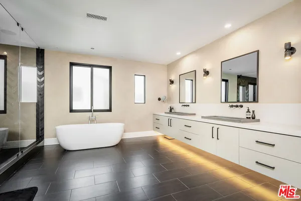 a large bathroom with a double vanity sink a mirror and a bathtub