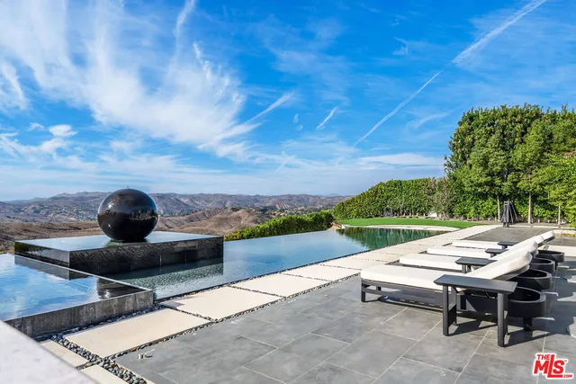 a view of a house with swimming pool and sitting area