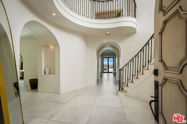 a view of staircase with railing and white walls
