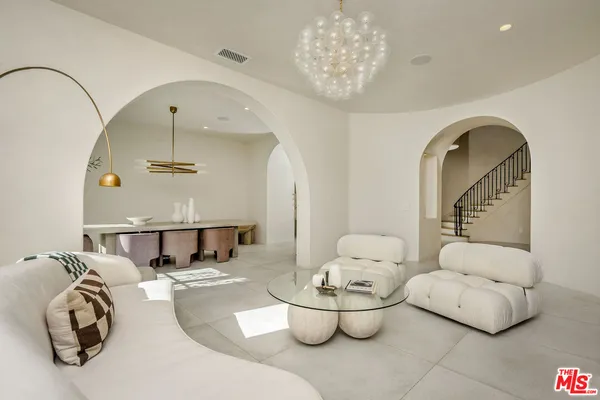 a living room with furniture and a chandelier