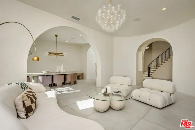 a living room with furniture and a chandelier
