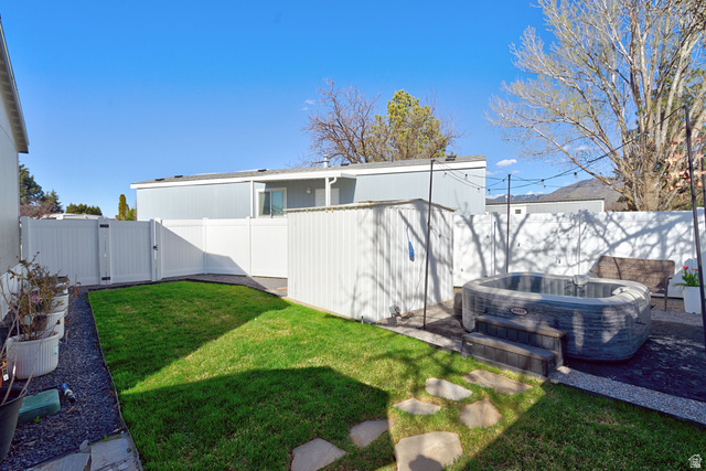 502 West 725 North Logan, UT 84321 - Photo 22 of 25 Fenced backyard featuring a gate, a hot tub, and a patio