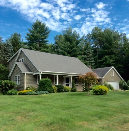 a front view of a house with a yard and trees