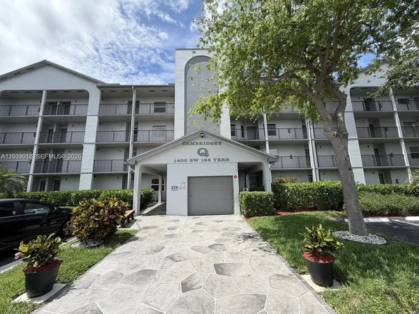 a front view of a building with a garden