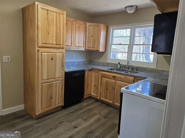 a kitchen with stainless steel appliances granite countertop a refrigerator a sink dishwasher a stove with wooden floor