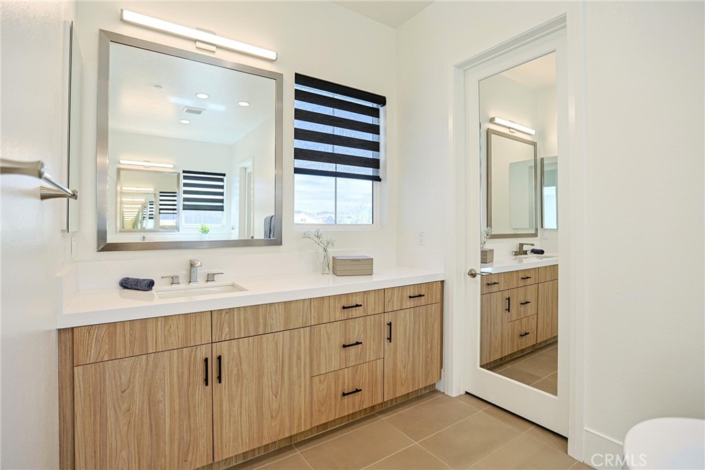 32213 Daybrook Terrace Temecula, CA 92591 - Photo 64 of 75 a bathroom with a double vanity sink a mirror and a bathtub