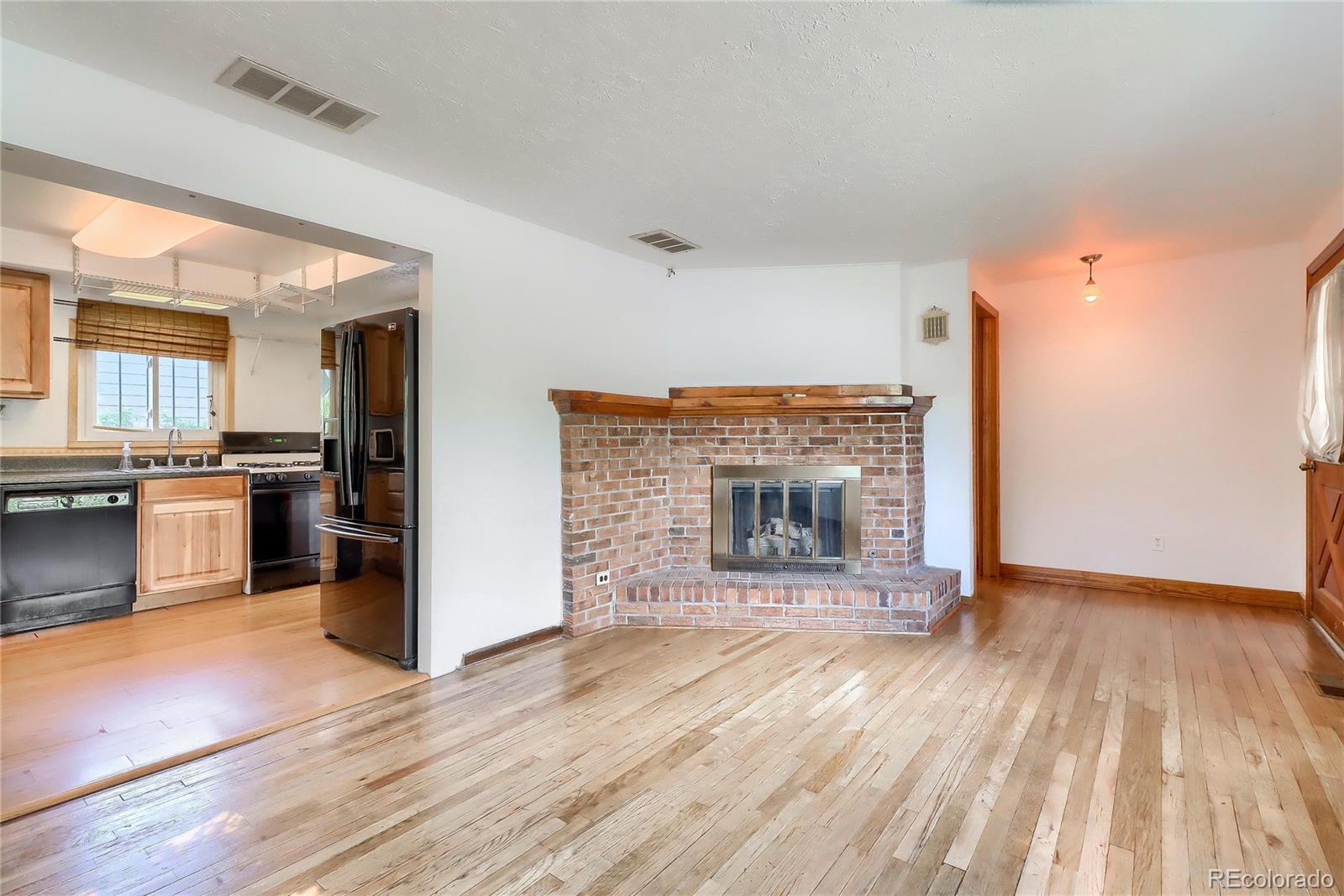 6201 East Tennessee Avenue Denver, CO 80224 - Photo 3 of 25 a view of kitchen and empty room with wooden floor