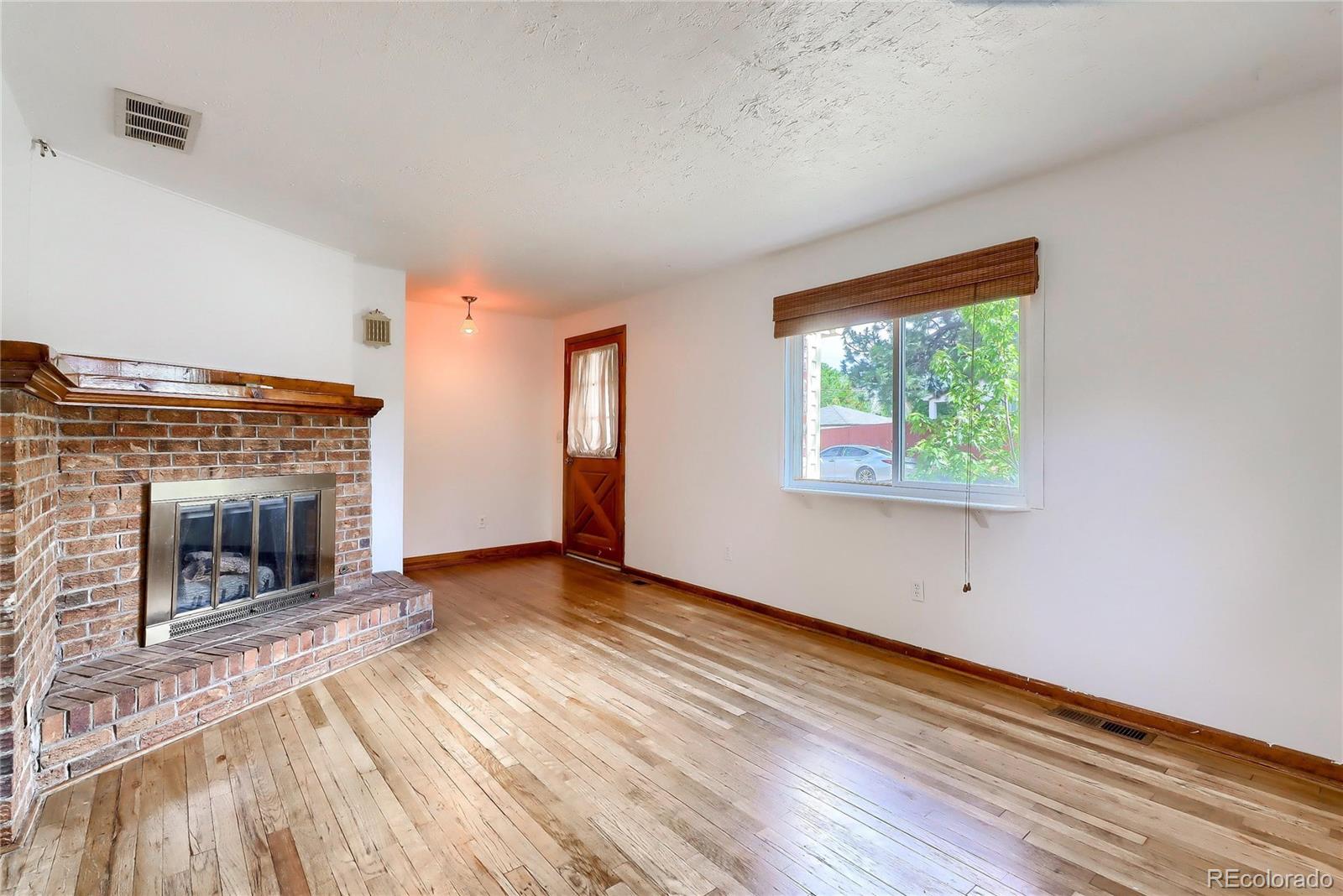 6201 East Tennessee Avenue Denver, CO 80224 - Photo 4 of 25 wooden floor fireplace and natural light in room