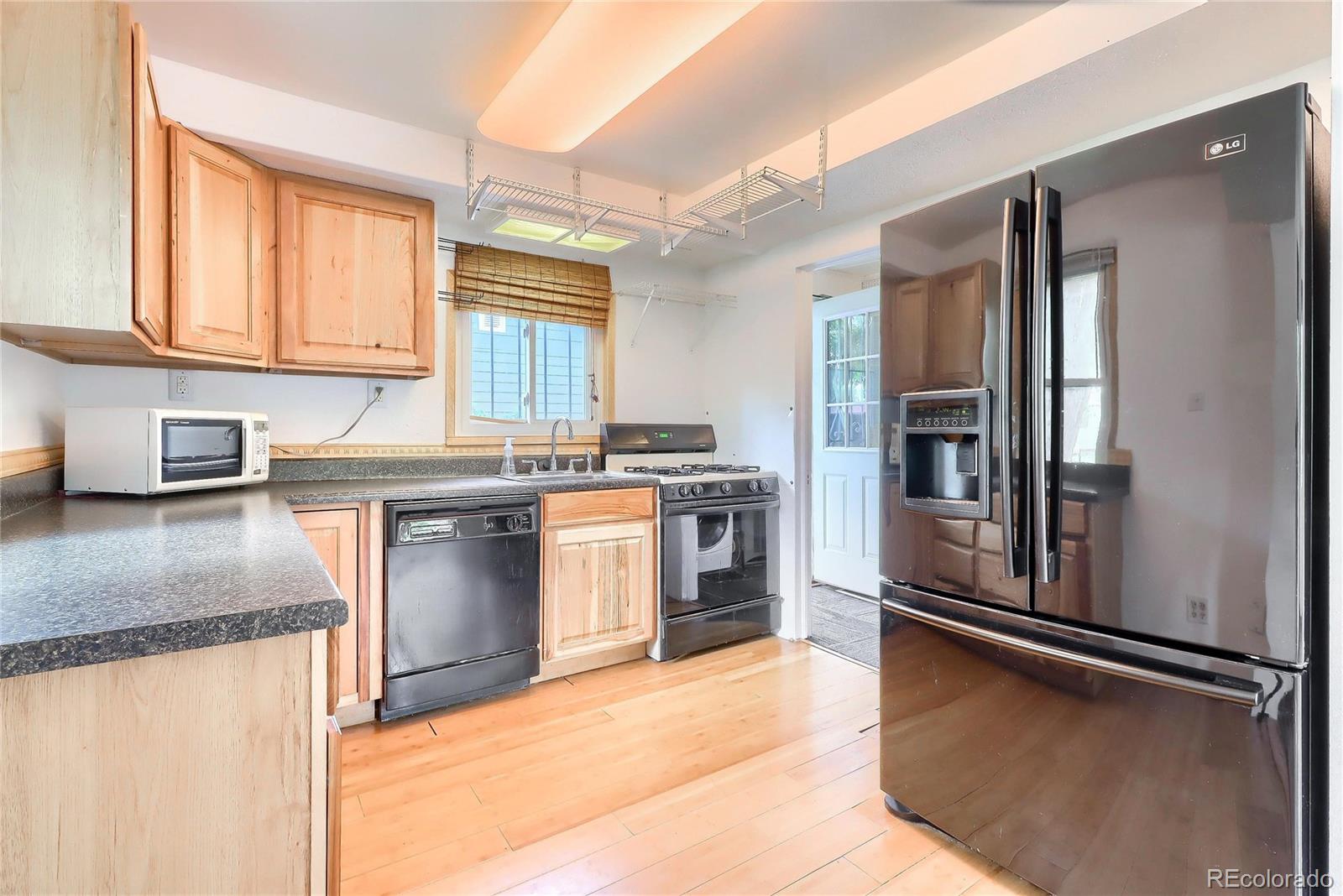 6201 East Tennessee Avenue Denver, CO 80224 - Photo 5 of 25 a kitchen with stainless steel appliances granite countertop a stove a sink and a refrigerator