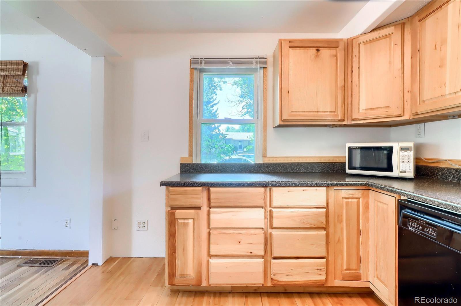 6201 East Tennessee Avenue Denver, CO 80224 - Photo 6 of 25 a kitchen with stainless steel appliances a window and cabinets