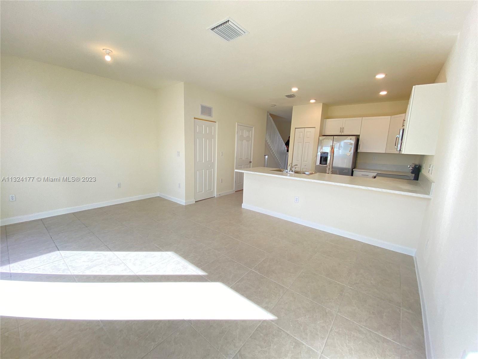 Hialeah Hialeah, FL 33018 - Photo 3 of 30 a large white kitchen with a sink a large mirror and cabinets