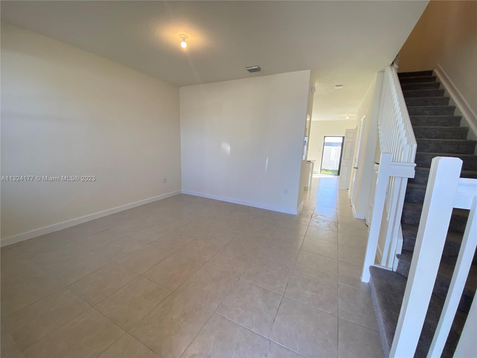 Hialeah Hialeah, FL 33018 - Photo 8 of 30 an empty room with wooden floor and staircase