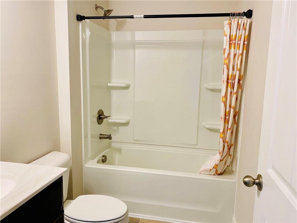 5101 Woodline View Circle Auburn, GA 30011 - Photo 20 of 26 a bathroom with a shower curtain and a toilet