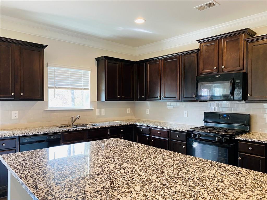 5101 Woodline View Circle Auburn, GA 30011 - Photo 6 of 26 a kitchen with granite countertop a stove a sink and a microwave