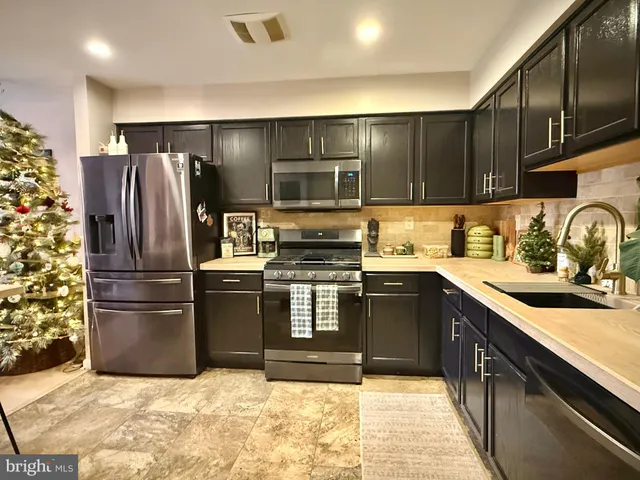 a kitchen with stainless steel appliances granite countertop a refrigerator and a sink