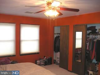 97 Country Club Road Pine Hill, NJ 08021 - Photo 4 of 6 a bedroom with a bed and a chandelier