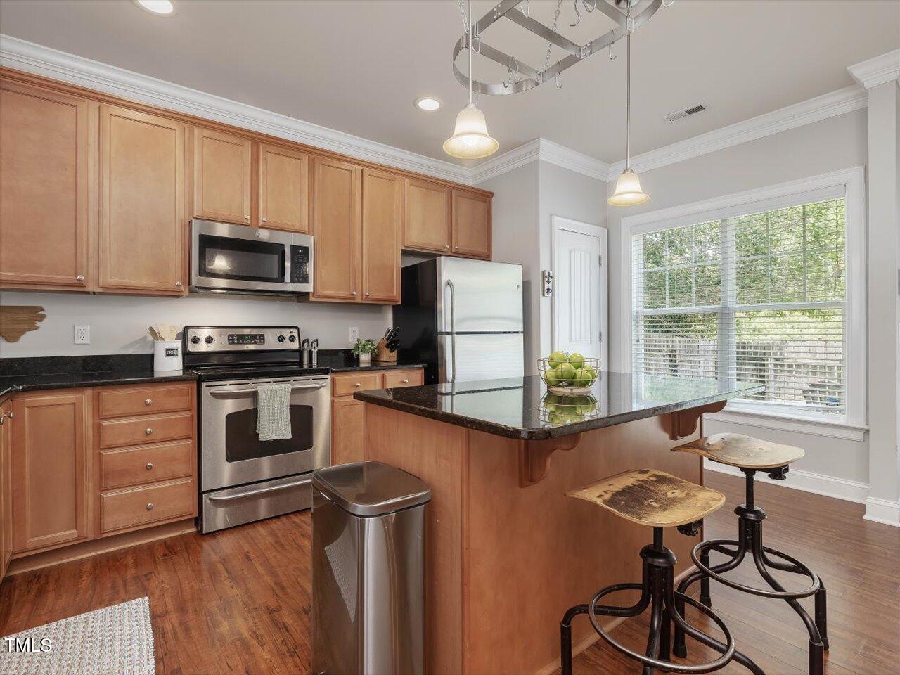 7712 ACC Boulevard Raleigh, NC 27617 - Photo 13 of 38 a kitchen with stainless steel appliances a stove a sink refrigerator and a microwave