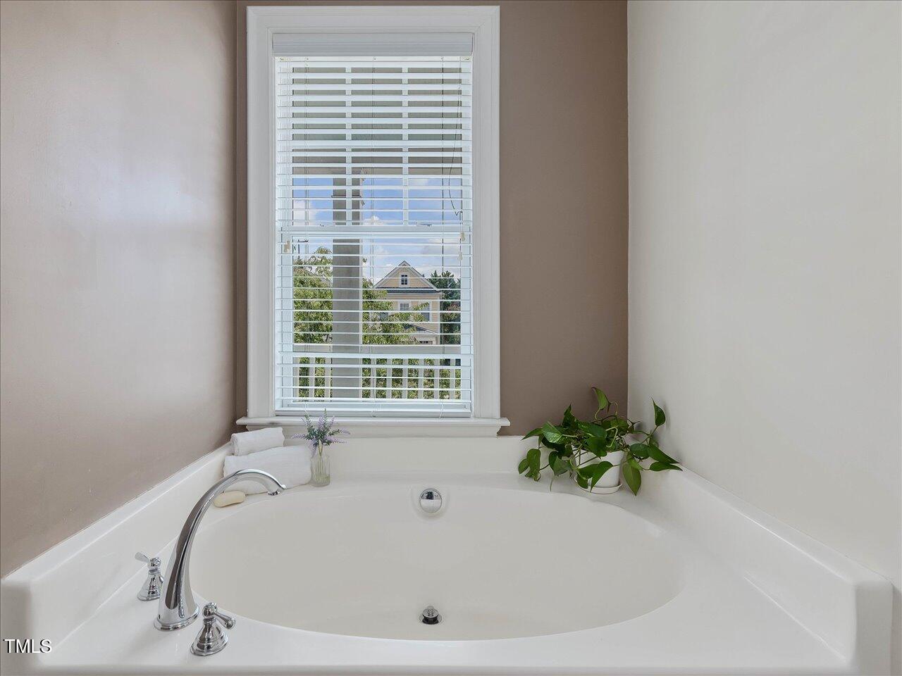 7712 ACC Boulevard Raleigh, NC 27617 - Photo 24 of 38 a white bath tub sitting in a bathroom next to a window