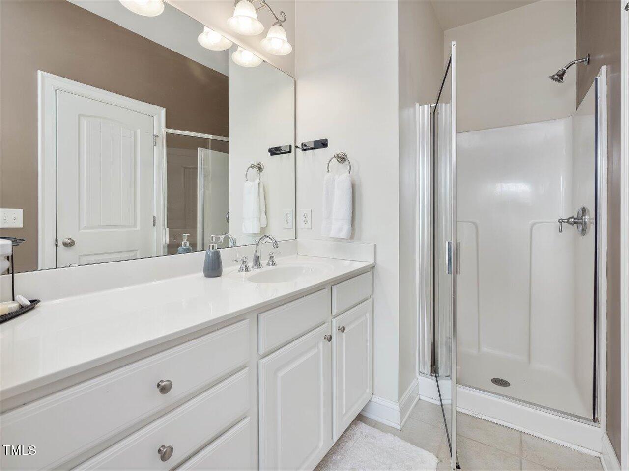 7712 ACC Boulevard Raleigh, NC 27617 - Photo 25 of 38 a bathroom with a sink vanity granite shower and a mirror