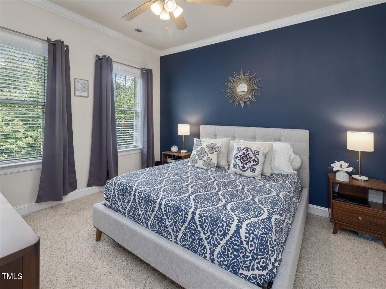 7712 ACC Boulevard Raleigh, NC 27617 - Photo 27 of 38 a bedroom with a large bed and a chandelier