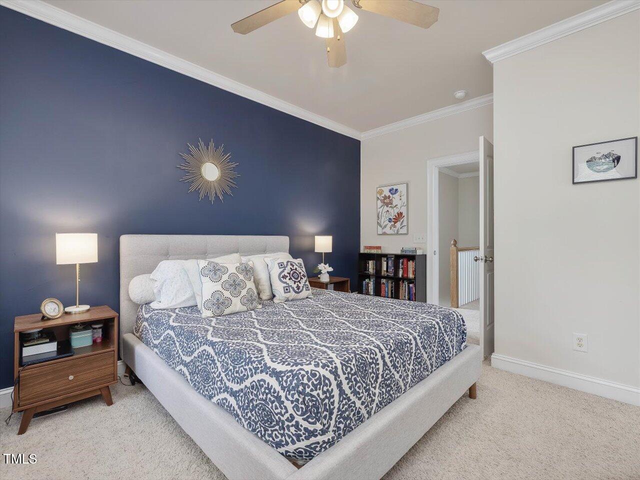 7712 ACC Boulevard Raleigh, NC 27617 - Photo 28 of 38 a bedroom with a bed and a chandelier