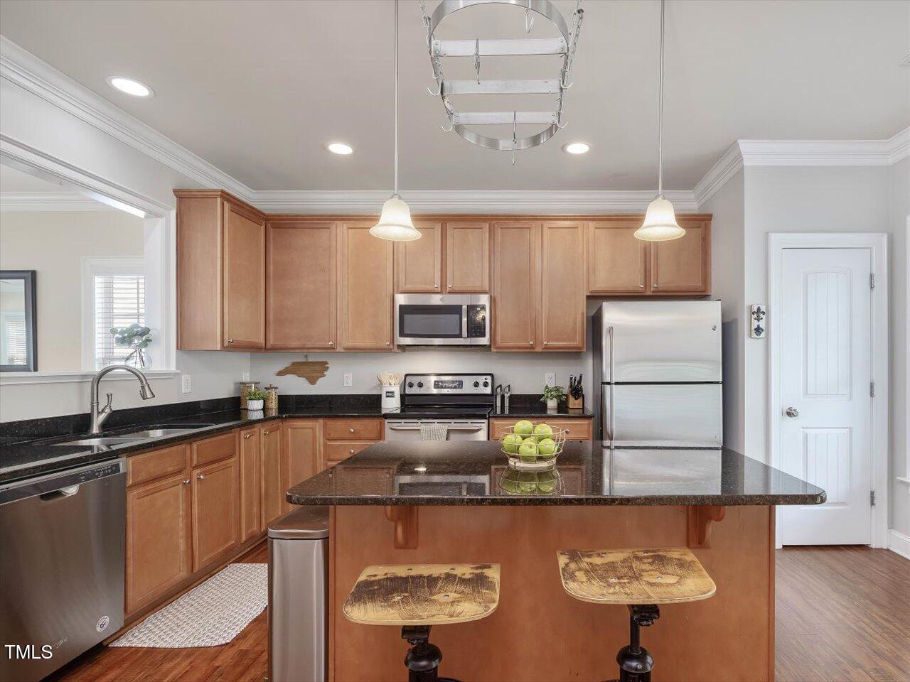 7712 ACC Boulevard Raleigh, NC 27617 - Photo 3 of 38 a kitchen with stainless steel appliances granite countertop a sink a stove and a refrigerator