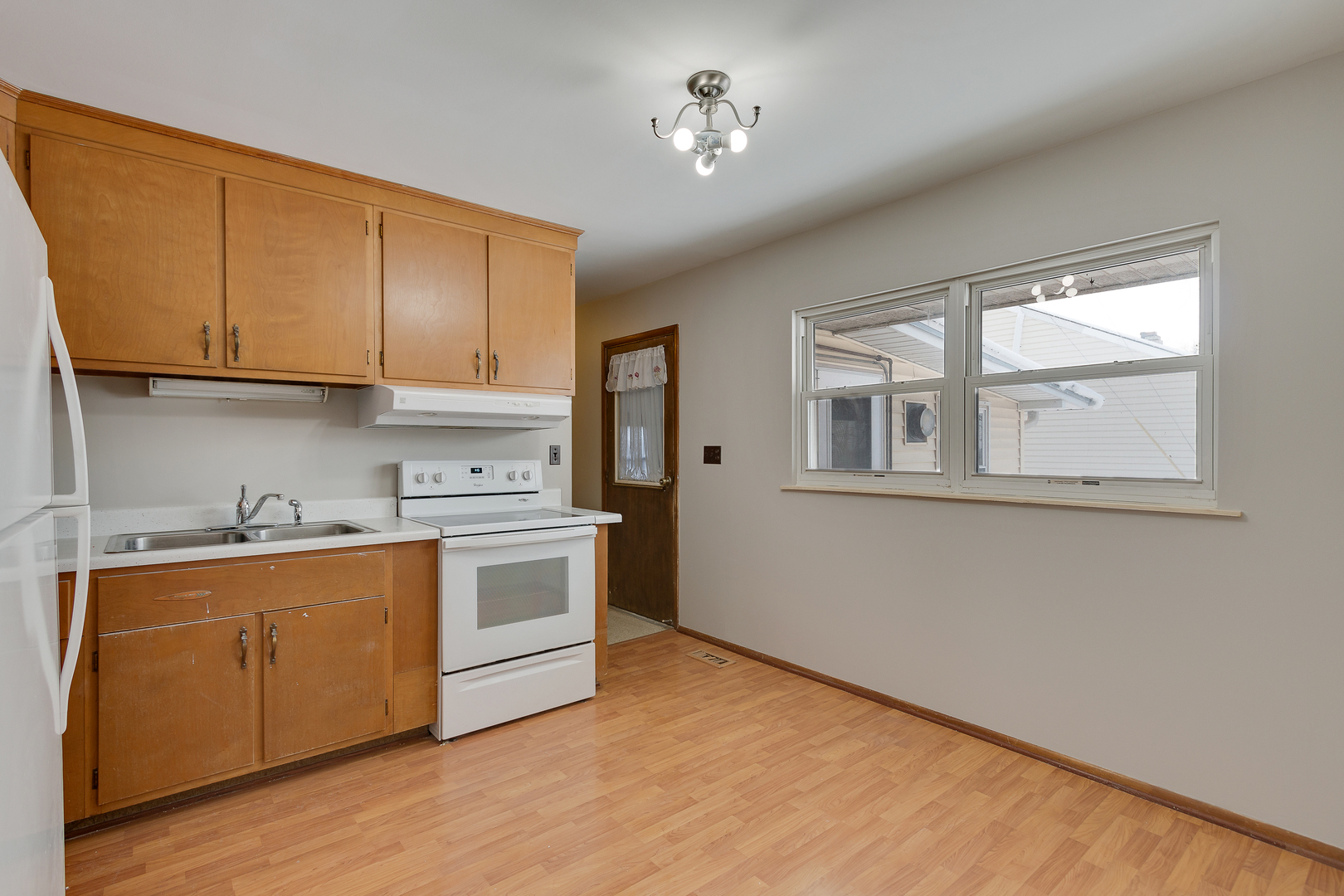 1240 Post Road Aurora, IL 60506 - Photo 6 of 15 a kitchen with stainless steel appliances granite countertop a stove a sink and white cabinets with wooden floor next to windows