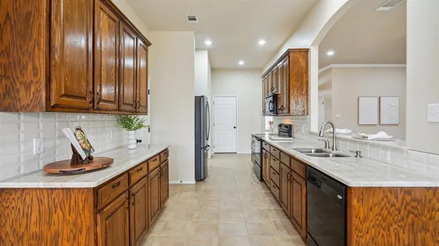 a kitchen with stainless steel appliances a sink stove and cabinets