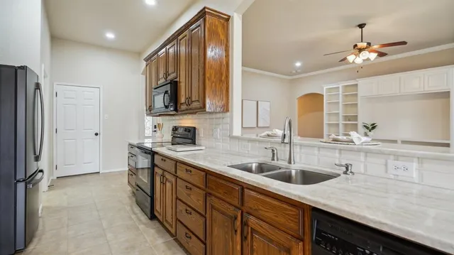 a kitchen with stainless steel appliances granite countertop a sink refrigerator and cabinets
