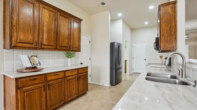a kitchen with stainless steel appliances granite countertop a refrigerator and a sink