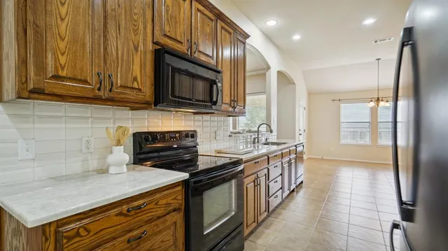 a kitchen with stainless steel appliances granite countertop a stove a sink and a microwave