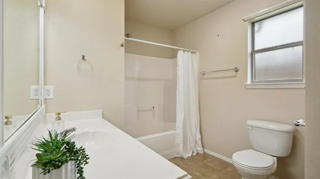 a white toilet sitting next to a bath tub