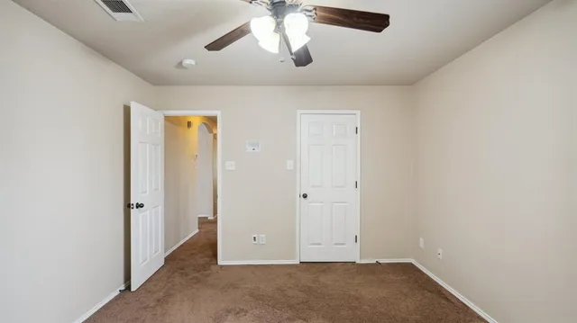 an empty room with chandelier fan