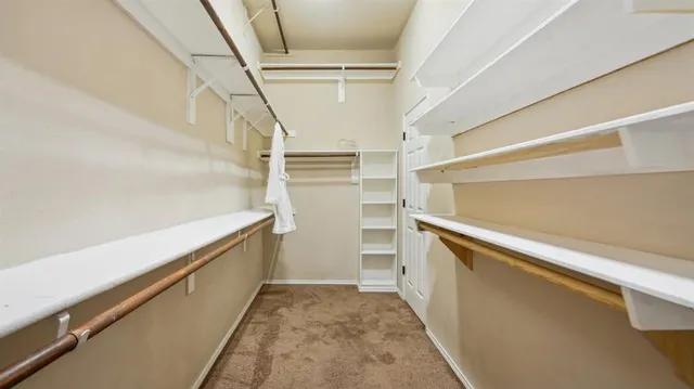 an empty room with chandelier fan and windows